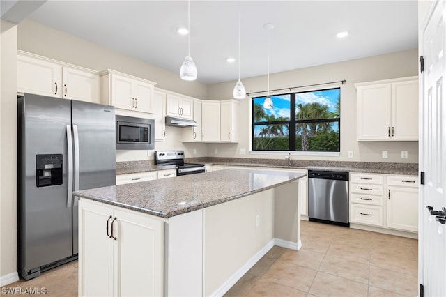 kitchen with white cabinets, a center island, stainless steel appliances, and dark stone counters