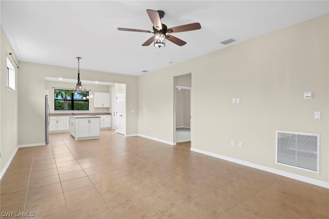 unfurnished living room with ceiling fan and light tile patterned flooring