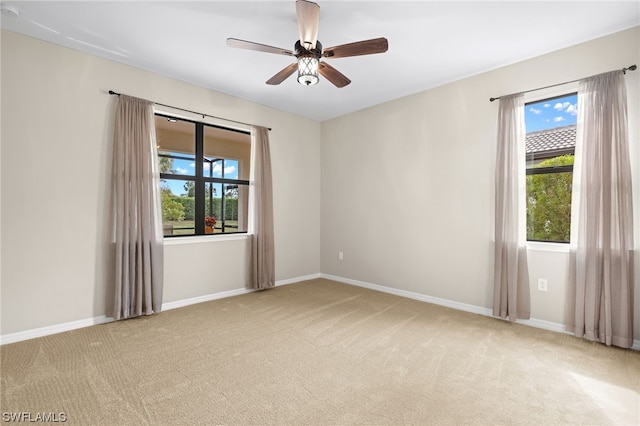 unfurnished room with ceiling fan and light carpet