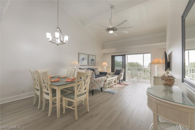 dining area with ceiling fan with notable chandelier, beam ceiling, hardwood / wood-style floors, and high vaulted ceiling