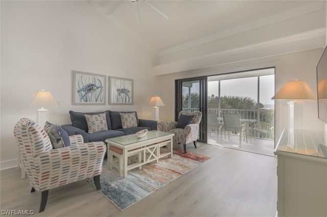 living room featuring ceiling fan, light hardwood / wood-style flooring, and high vaulted ceiling