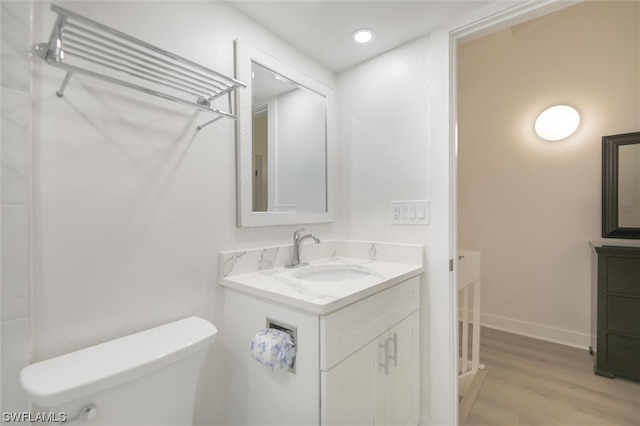 bathroom featuring vanity, toilet, and hardwood / wood-style flooring