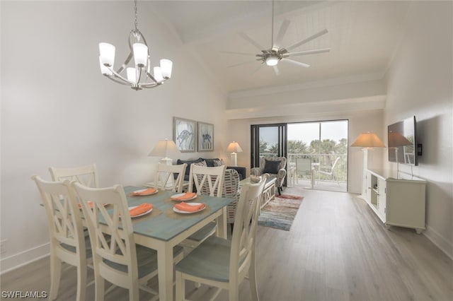 dining area featuring ceiling fan with notable chandelier, light hardwood / wood-style flooring, and high vaulted ceiling