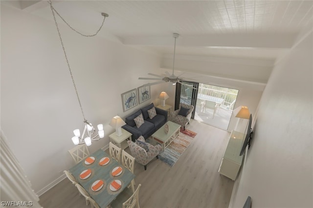 unfurnished living room with ceiling fan with notable chandelier, beamed ceiling, and hardwood / wood-style flooring