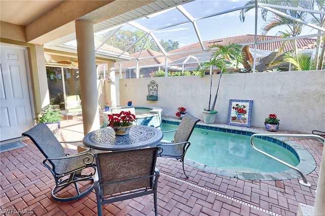 view of swimming pool featuring glass enclosure and a patio area