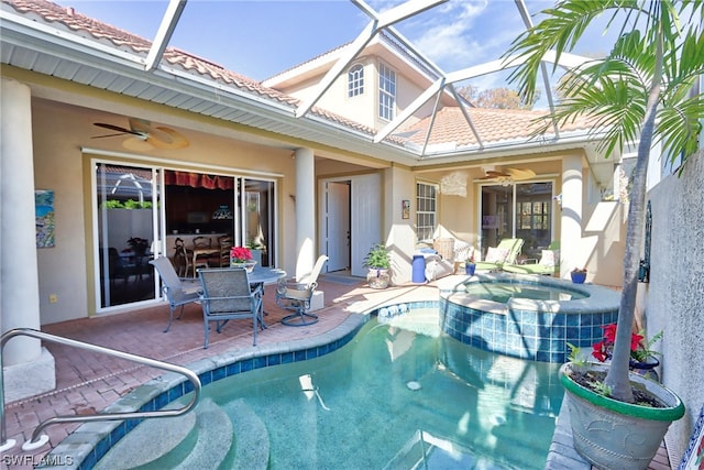 view of pool featuring a lanai, a patio, an in ground hot tub, and ceiling fan