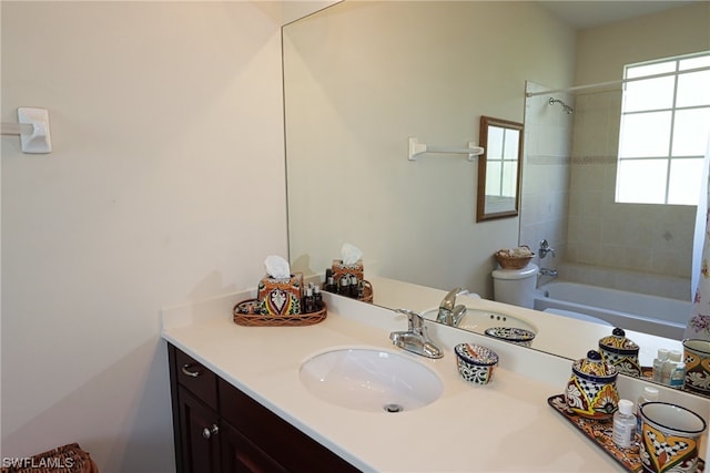 full bathroom with vanity, tiled shower / bath, and toilet