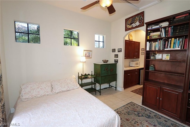 tiled bedroom with ensuite bath and ceiling fan