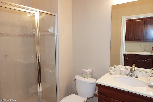 bathroom featuring a shower with shower door, vanity, and toilet