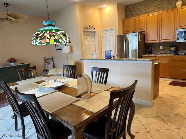 tiled dining room with a towering ceiling and ceiling fan