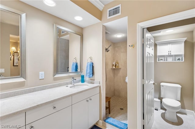 bathroom featuring tiled shower, vanity, toilet, and tile patterned floors