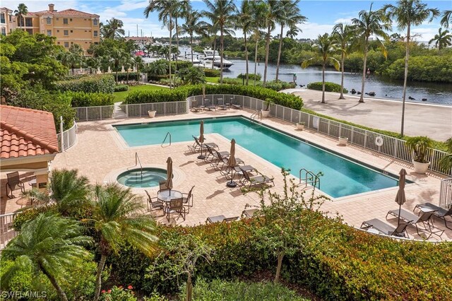 view of pool featuring a patio area, a community hot tub, and a water view