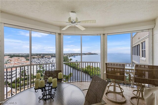 sunroom with a water view and ceiling fan