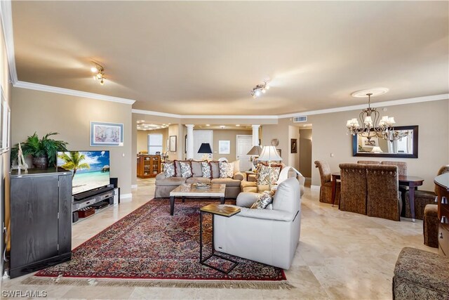 living room featuring crown molding, rail lighting, decorative columns, and a notable chandelier