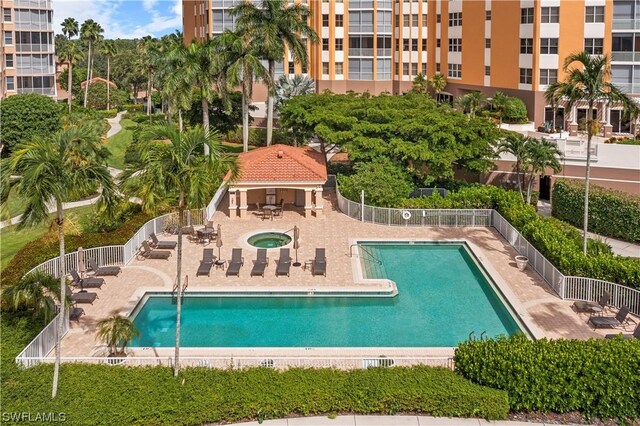 view of swimming pool featuring a hot tub and a patio