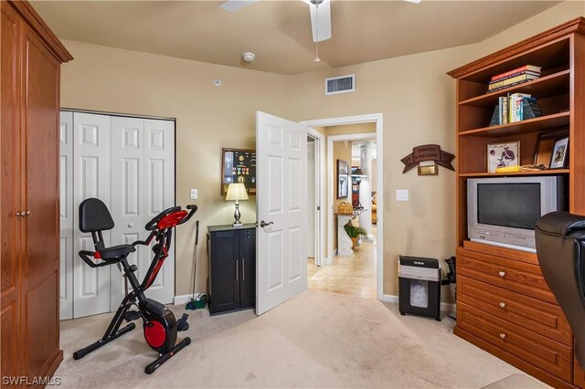 exercise room featuring ceiling fan and light carpet