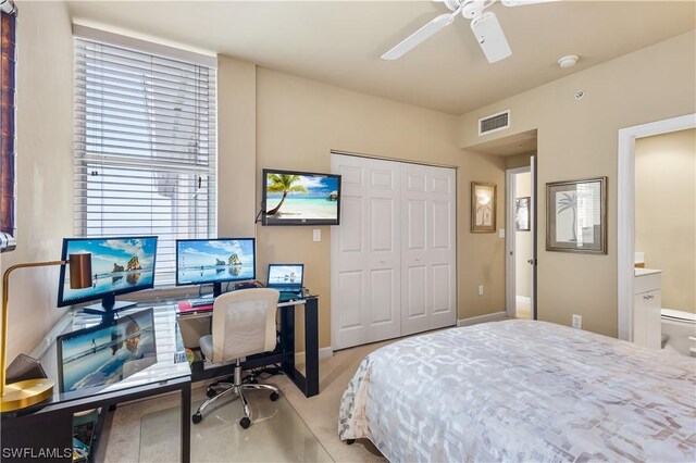 bedroom featuring ensuite bathroom, light carpet, ceiling fan, and a closet