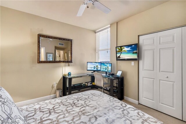 bedroom featuring light colored carpet, a closet, and ceiling fan