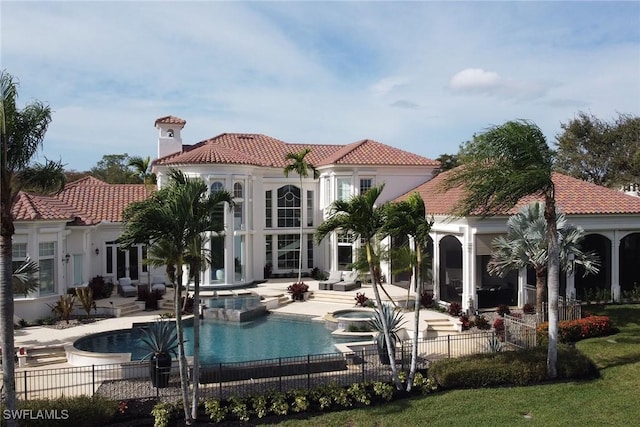 back of house with a swimming pool with hot tub, an outdoor hangout area, and a patio