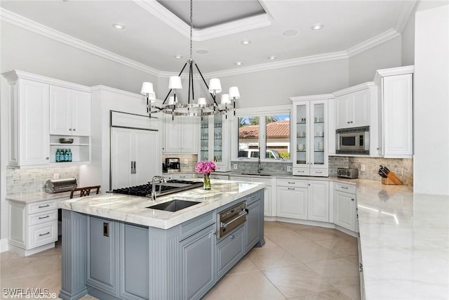 kitchen featuring built in appliances, gray cabinetry, white cabinetry, and a warming drawer