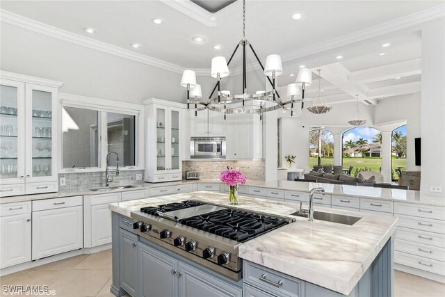 kitchen with a center island with sink, sink, white cabinets, and stainless steel appliances