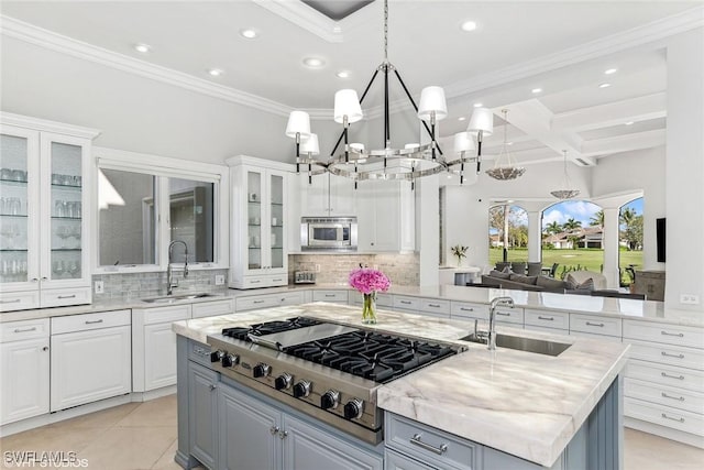 kitchen with a center island, white cabinetry, stainless steel appliances, and a sink