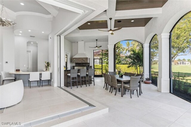 dining room featuring ceiling fan, light tile patterned flooring, and decorative columns