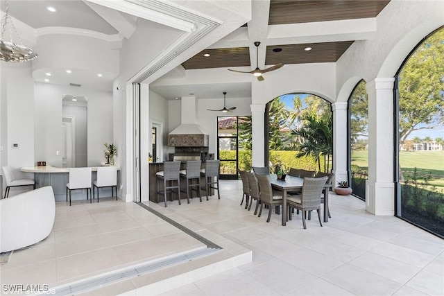 view of patio / terrace with outdoor wet bar, exterior kitchen, outdoor dining area, and a ceiling fan