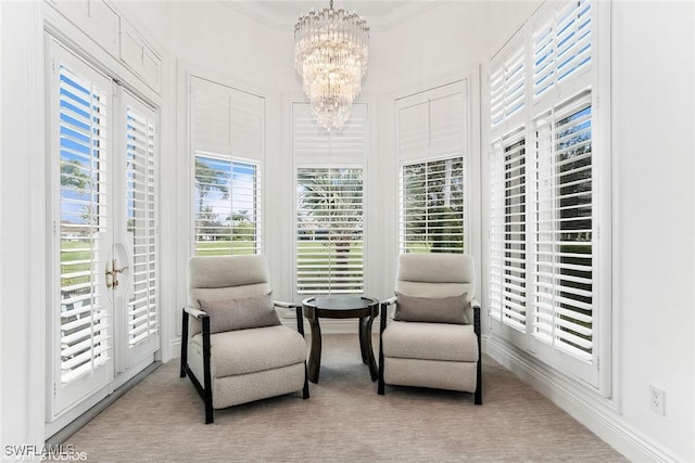 living area with a wealth of natural light, light carpet, and a notable chandelier