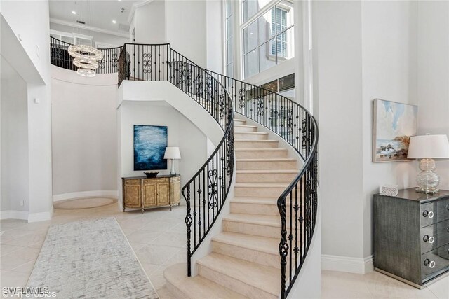 stairway featuring tile patterned flooring and a towering ceiling