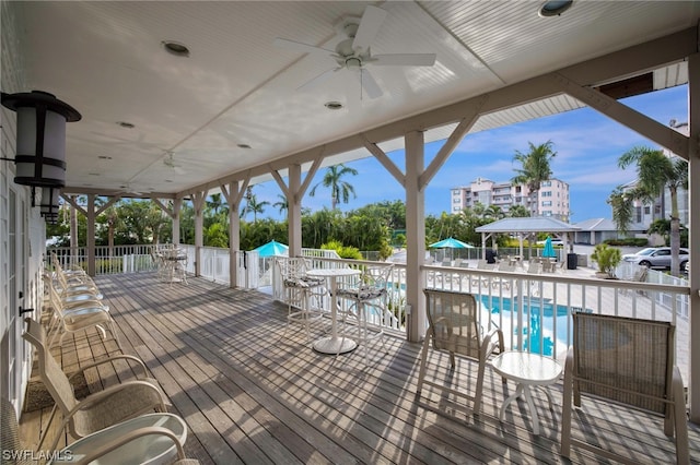 wooden deck featuring ceiling fan and a community pool