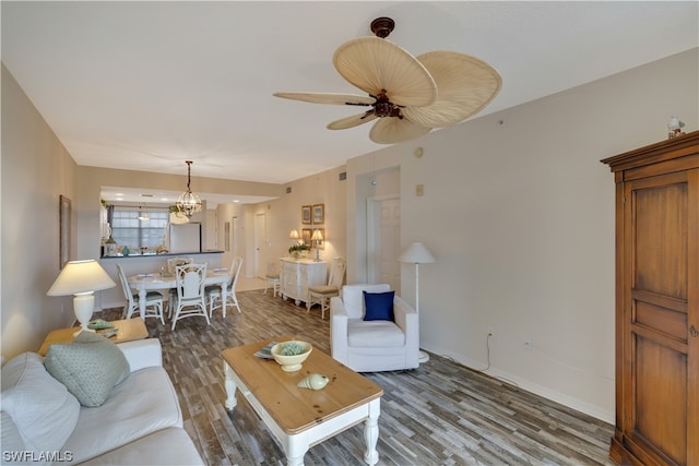 living room featuring hardwood / wood-style flooring and ceiling fan with notable chandelier