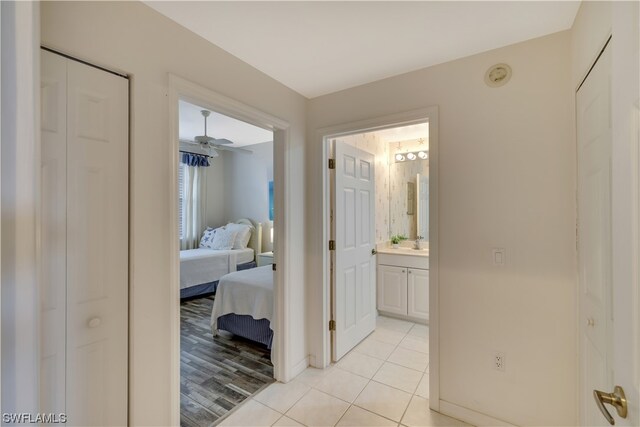 hall with sink and light tile patterned flooring