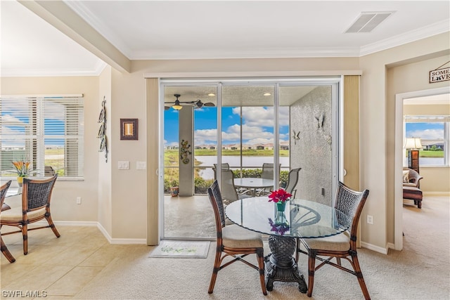 tiled dining area with ornamental molding and a wealth of natural light