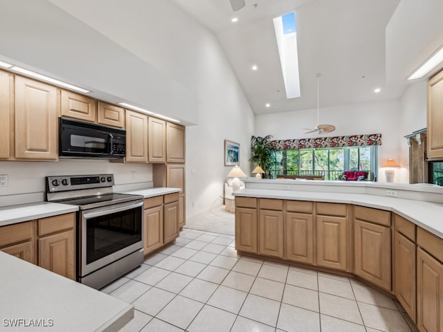 kitchen with a skylight, stainless steel electric stove, ceiling fan, light tile patterned floors, and high vaulted ceiling