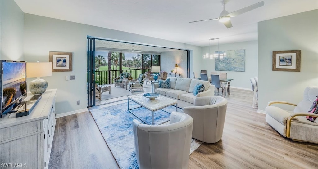 living room with ceiling fan and light hardwood / wood-style flooring