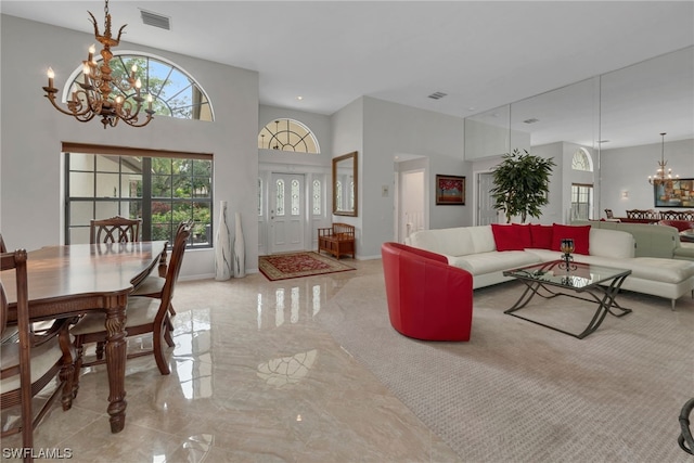 living room with a towering ceiling and a chandelier