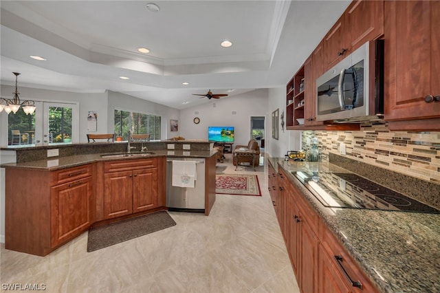 kitchen with sink, french doors, dark stone countertops, pendant lighting, and appliances with stainless steel finishes