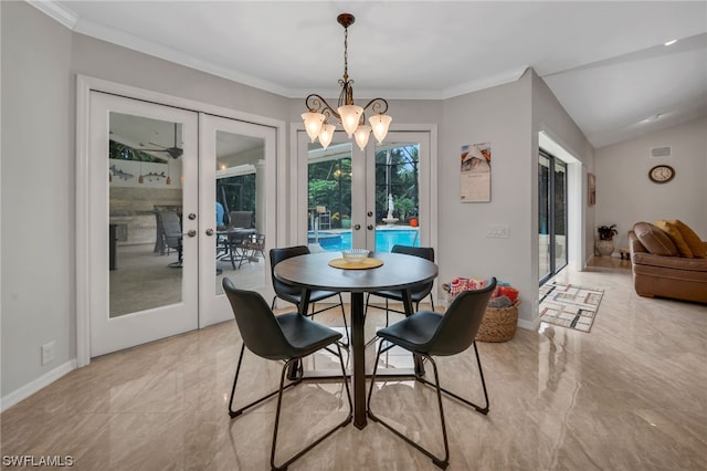 dining area with crown molding, french doors, a chandelier, and lofted ceiling