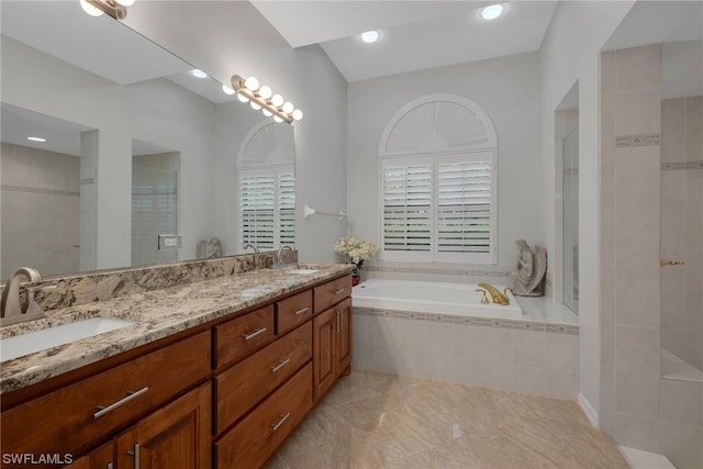 bathroom featuring vanity and tiled bath