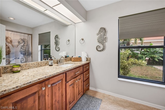 bathroom featuring tile patterned flooring, vanity, and a healthy amount of sunlight