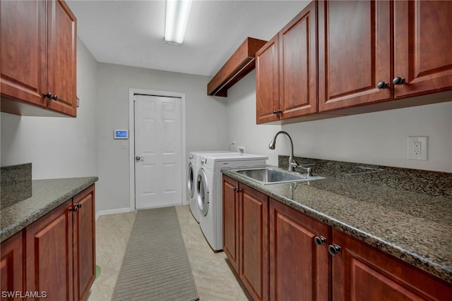 clothes washing area with cabinets, sink, and washing machine and clothes dryer