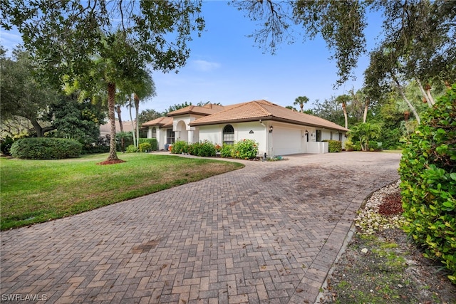 view of front of property featuring a front lawn and a garage