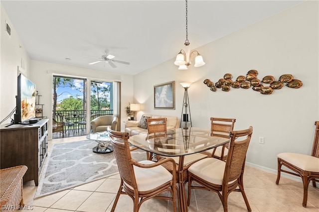 dining area featuring ceiling fan with notable chandelier, light tile floors, and lofted ceiling