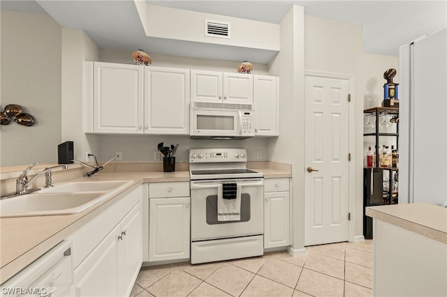 kitchen with light tile floors, white appliances, white cabinetry, and sink