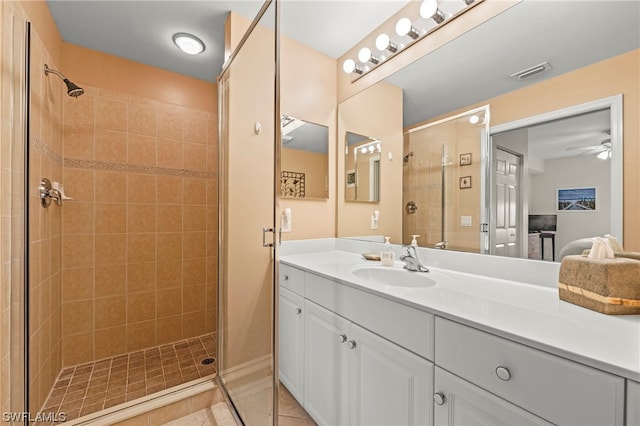 bathroom featuring a shower with door, tile floors, oversized vanity, and ceiling fan