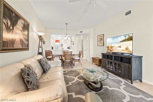 living room with light tile floors and ceiling fan with notable chandelier