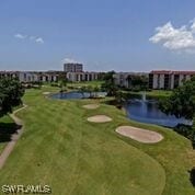 view of property's community with a yard and a water view