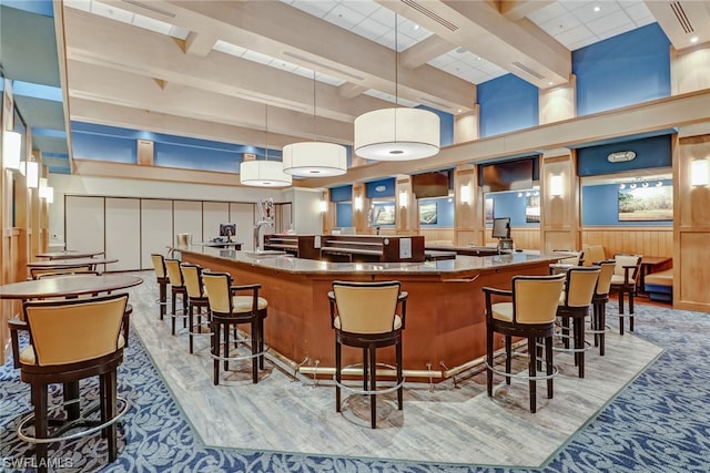 bar with beamed ceiling, a towering ceiling, and pendant lighting