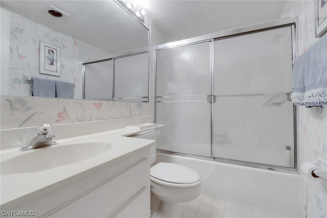 full bathroom featuring vanity, combined bath / shower with glass door, tile flooring, and toilet